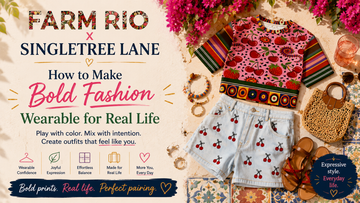 Hero graphic for Farm Rio x SingleTree Lane featuring cherry denim shorts and a colorful fruit-print cropped pullover styled as bold wearable art fashion for real life.