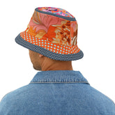 Person wearing a colorful bucket hat with floral design on a white background